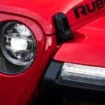 A closeup of the headlight on a red 2019 Jeep Wrangler Rubicon