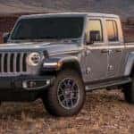 A grey Jeep Gladiator is parked on a hill over looking mountains near Colorado Springs, CO.