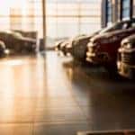 Used cars that are in a dealership showroom are shown.