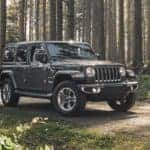 A man is walking away from his 2020 Jeep Wrangler Unlimited in the woods that he purchased from a Colorado Springs Jeep dealership.