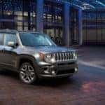 A grey Certified Pre-Owned 2019 Jeep Renegade is parked at a dealership at night in Colorado Springs, CO.