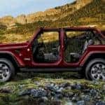 A burgundy 2021 Jeep Wrangler Unlimited is shown from the side in front of hills.