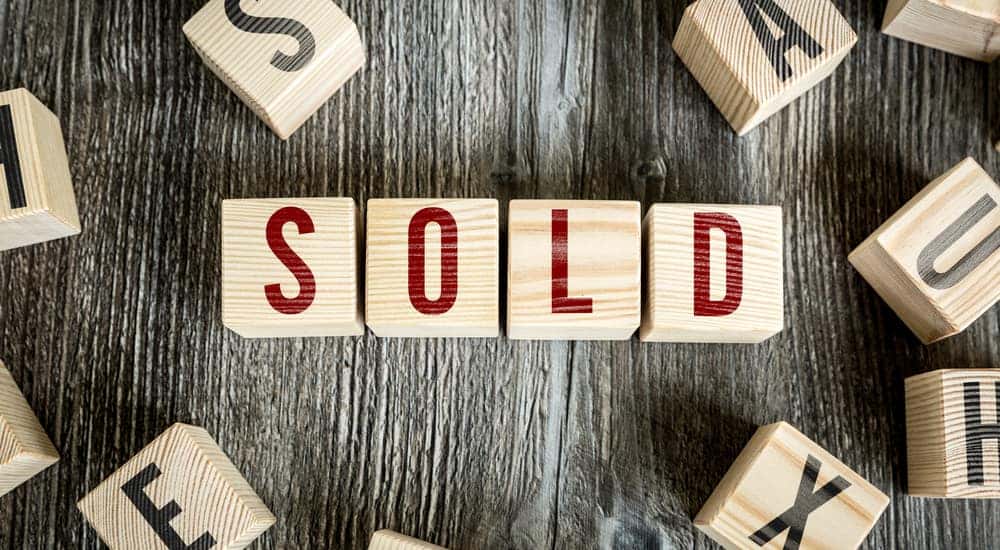 Brown blocks with black letters on them surrounding blocks with red letters that spell out the word "SOLD"