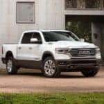 A white 2019 Ram 1500 diesel is parked in front of a metal building.