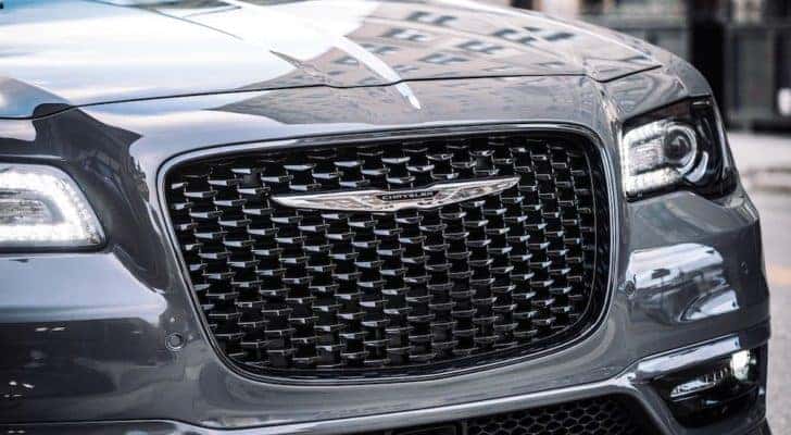 A closeup shows the grille on a gray 2018 Chrysler 300 at a pre-owned Chrysler dealer.