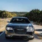 A gray 2020 Chrysler 300 is shown from the front driving on a highway after leaving a pre-owned Chrysler dealer.