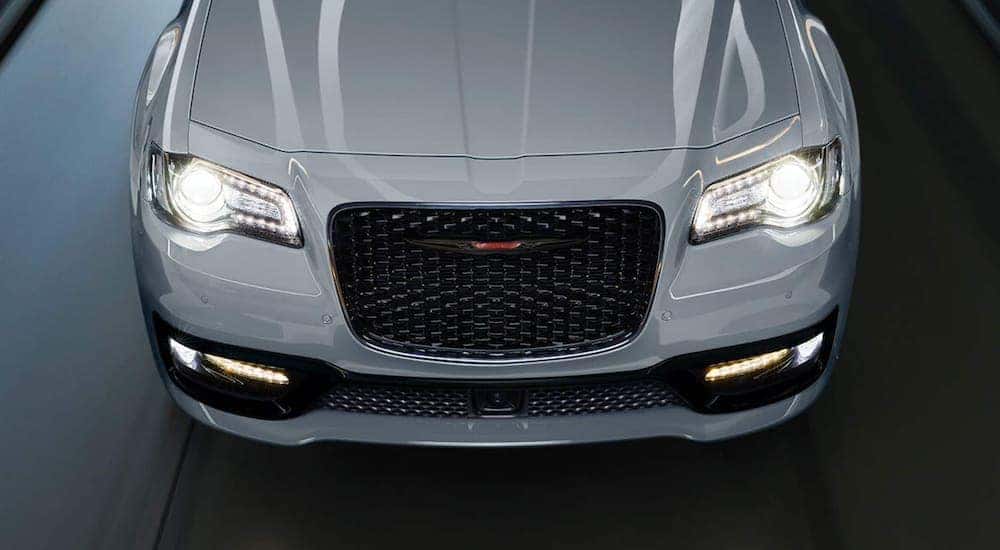 The front of a 2021 Chrysler 300 is shown with the headlights on.