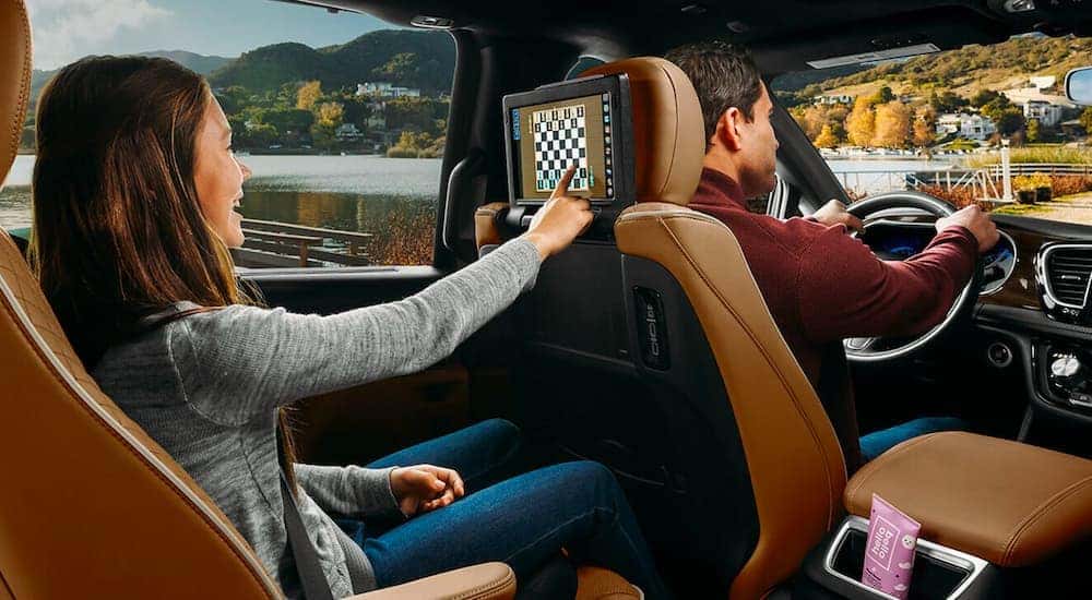 A child is shown playing chess on the headrest screen in a 2020 Chrysler Pacifica Hybrid Pinnacle.