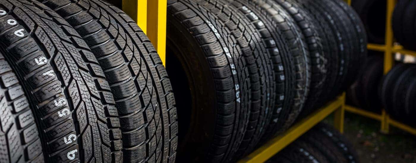 A row of tires is shown on a yellow rack.