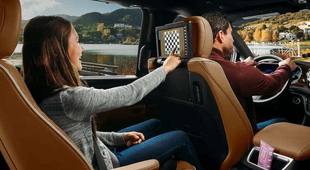 A child is shown using the entertainment screen in a 2021 Chrysler Pacifica.