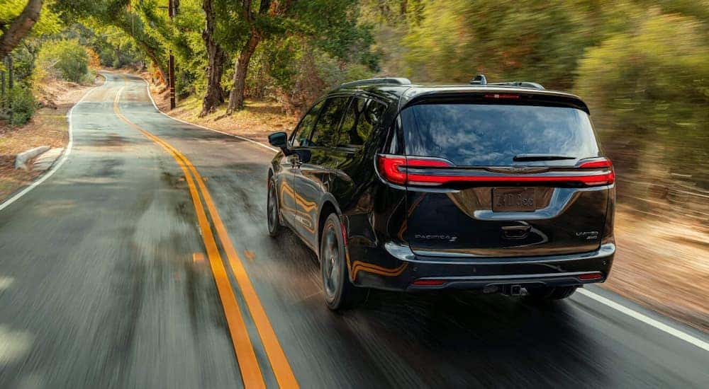 A black 2021 Chrysler Pacifica Limited is shown leaving a Colorado Springs Chrysler dealership.