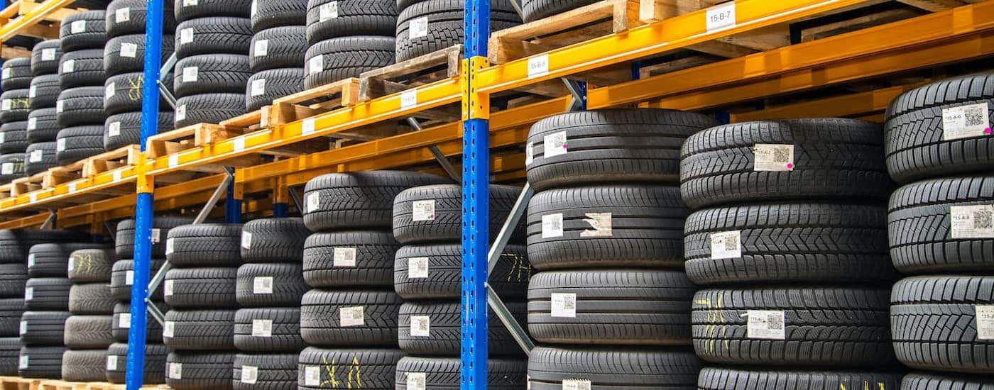 Stacks of tires are shown on yellow and blue pallet racking.