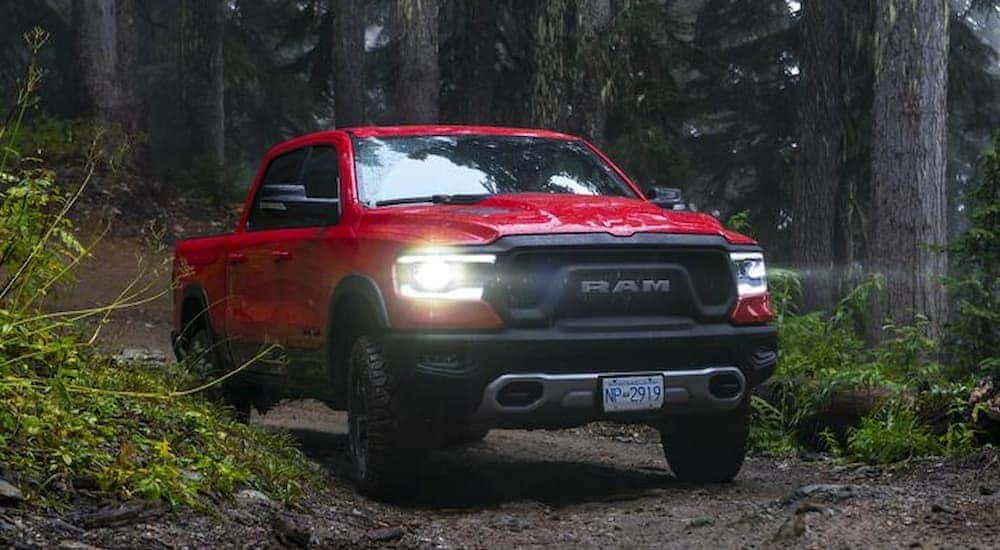 A red 2019 Ram 1500 Rebel is shown on a dirt road after leaving a certified pre-owned car dealer.