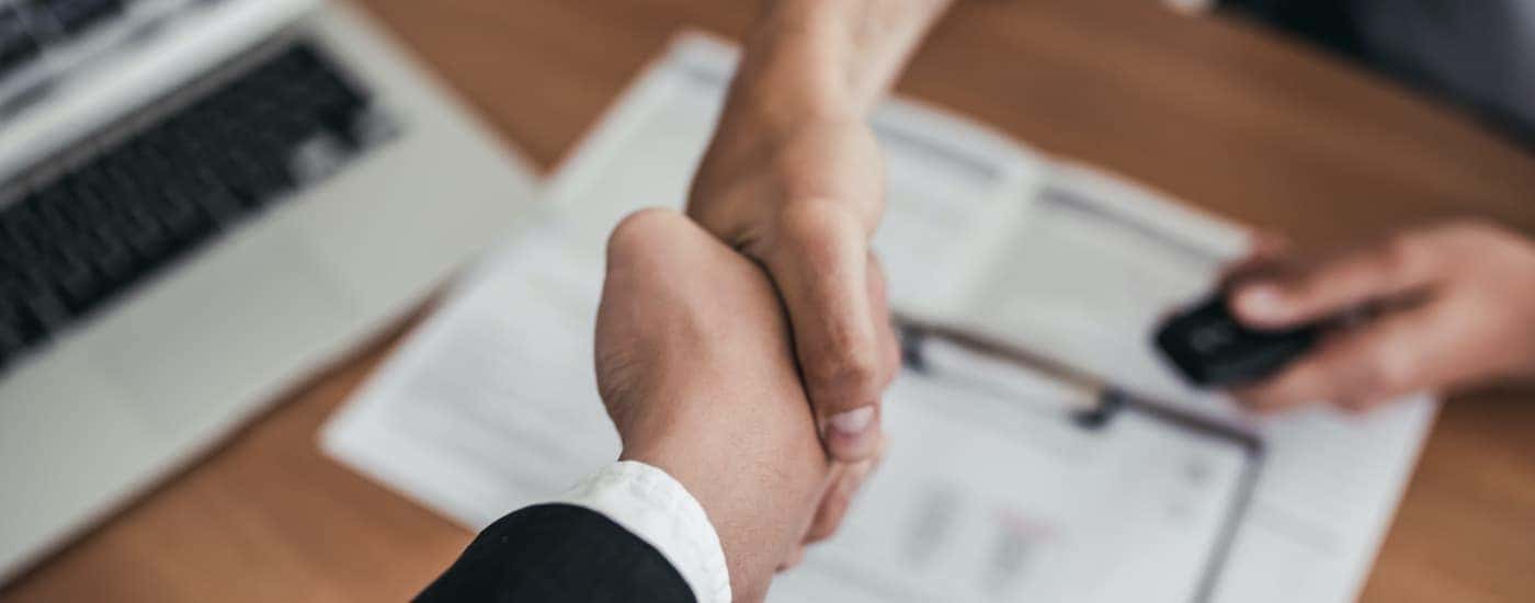 A salesperson is shaking hands with a customer.