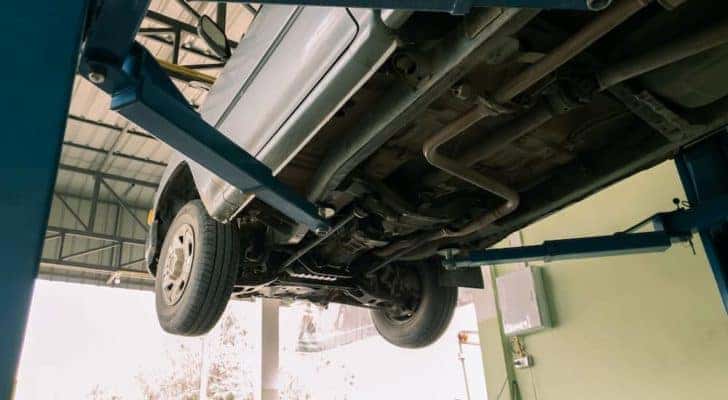 A truck is shown from a low angle on a lift during a Ram service near you.