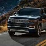 A black 2022 Grand Wagoneer is shown leaving a Colorado Grand Wagoneer dealer.