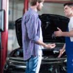A mechanic is shown speaking to a customer at a Colorado Springs auto service shop.