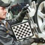 A mechanic is shown attaching a target to a vehicle at a shop that does auto alignments near you.