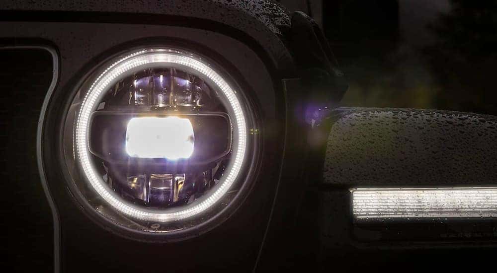 A close up shows the LED headlight on a black 2021 Jeep Wrangler.
