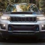 A silver 2022 Jeep Grand Cherokee 4xe is shown from the front driving on an open road after leaving a Jeep Grand Cherokee 4xe dealer.