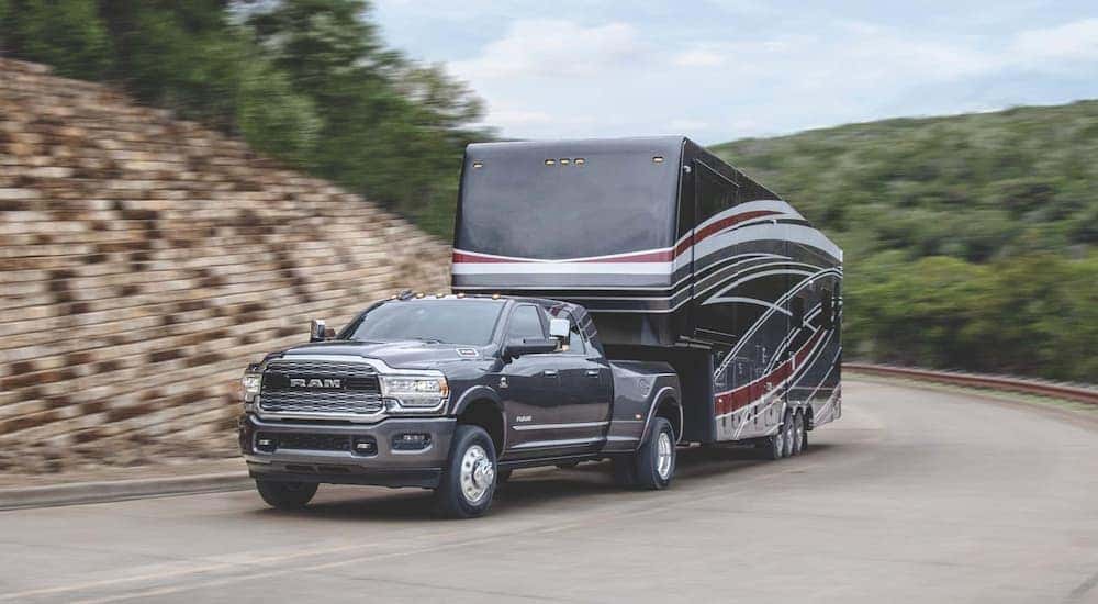 A grey 2022 Ram 3500 HD is shown from the front while towing a camper.