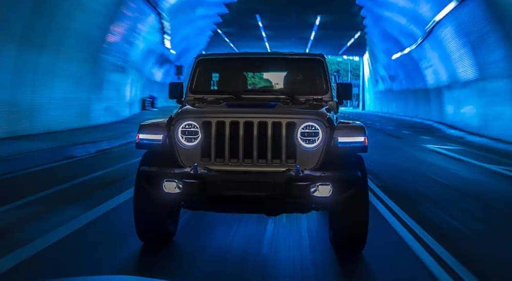 A grey 2021 Jeep Wrangler 4xe is shown from the front driving through a tunnel after visiting a Colorado Springs used Jeep dealer.