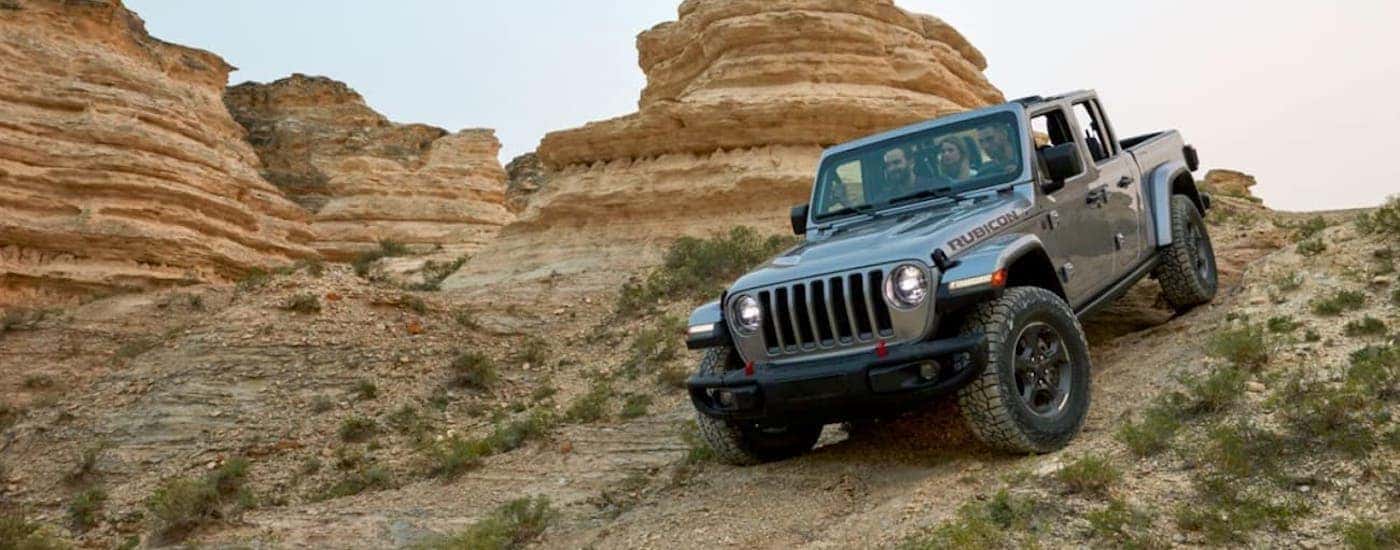 A grey 2020 Jeep Gladiator is shown from the front off-roading.