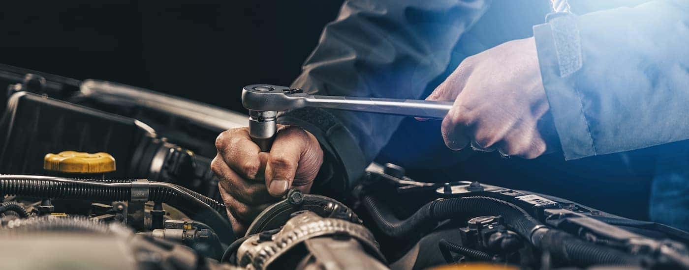 A mechanic is shown working on a vehicle at a Jeep service center.