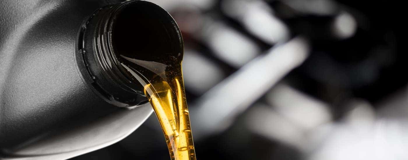 A close up of oil being poured is shown at a Jeep service center.