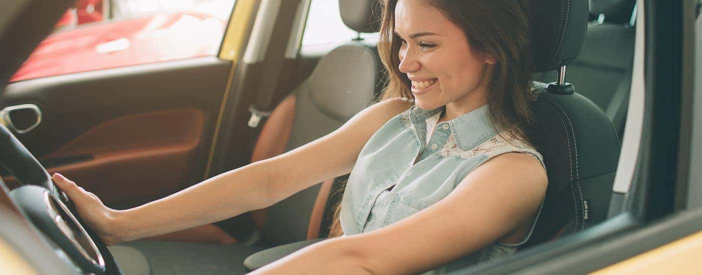 A person is shown sitting in the front seat of a car while valuing your car.