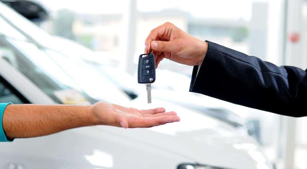 Keys are shown exchanging hands at a dealership after a customer asked a salesman to 'value my trade'.