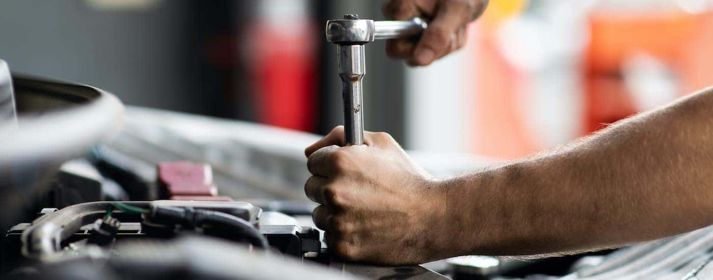 A mechanic is shown servicing a vehicle.