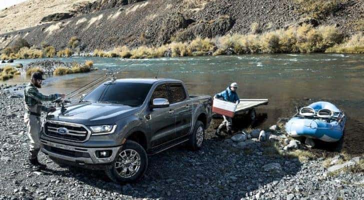A grey 2022 Ford Ranger Lariat is shown next to a small boat near a river.