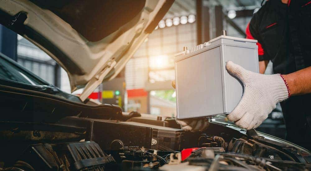 A mechanic is shown replacing a battery while performing Jeep winter battery service.