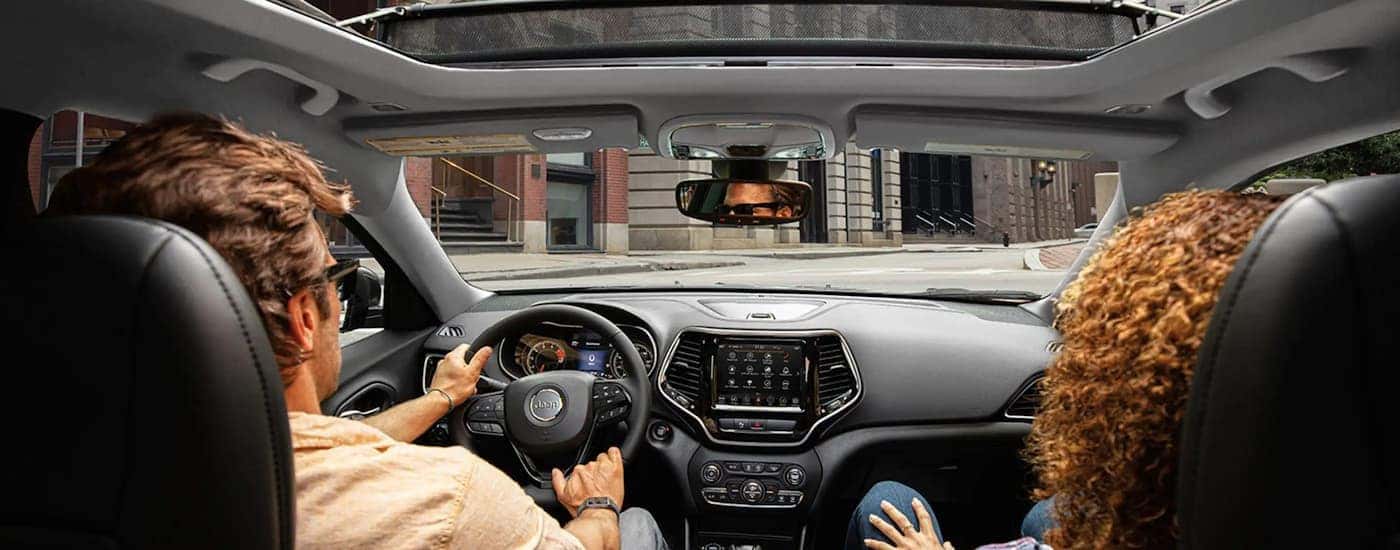 A couple is shown test driving a 2023 Jeep Cherokee Altitude for sale.