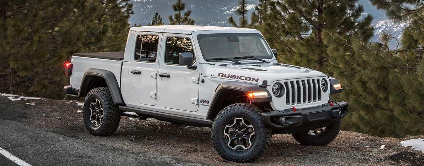 A white 2023 Jeep Gladiator Rubicon is shown parked on the side of a road. 