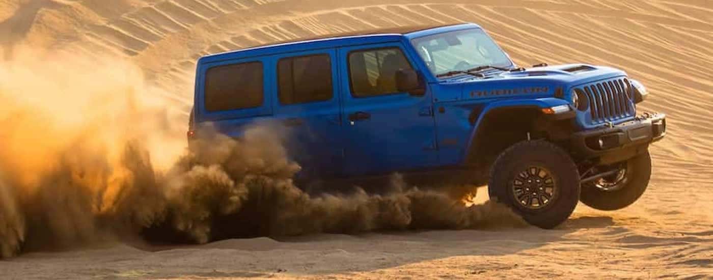 A blue 2021 Jeep Wrangler Rubicon 392 is shown from the side after leaving a dealer that has a used Jeep Wrangler for sale near Castle Rock, CO.