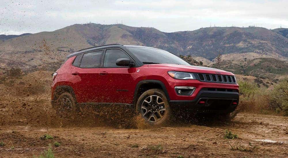 A red 2021 Jeep Compass Trailhawk is shown from the side at an angle.