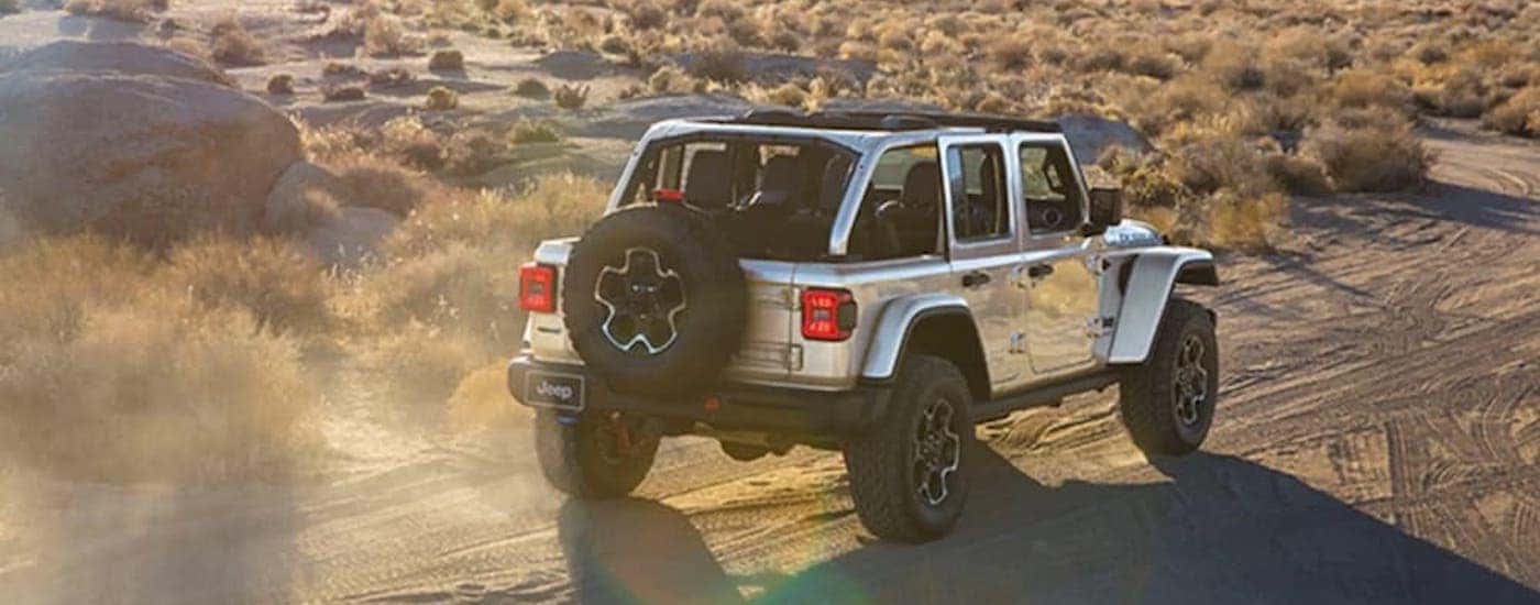 A silver 2022 Jeep Wrangler Rubicon 4xe is shown from the rear at an angle.