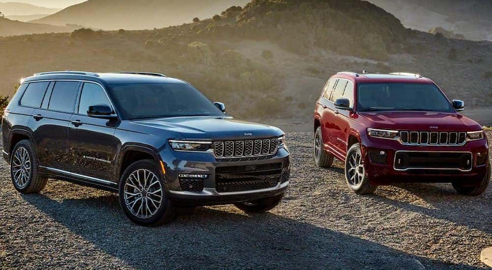 A grey and a red 2023 Jeep Grand Cherokee are shown from the front.
