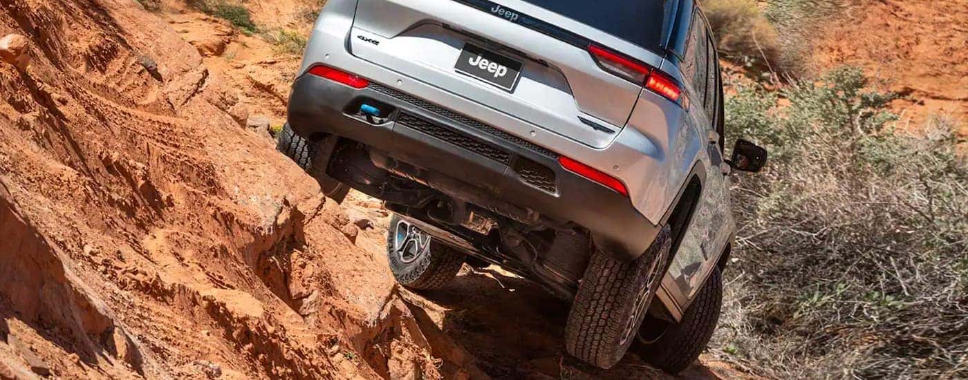 A popular Jeep 4xe Hybrid for sale, a silver 2023 Jeep Grand Cherokee 4xe is shown off-roading.