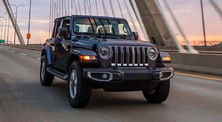 A 2022 Jeep Wrangler is shown from the front at an angle while crossing a bridge.