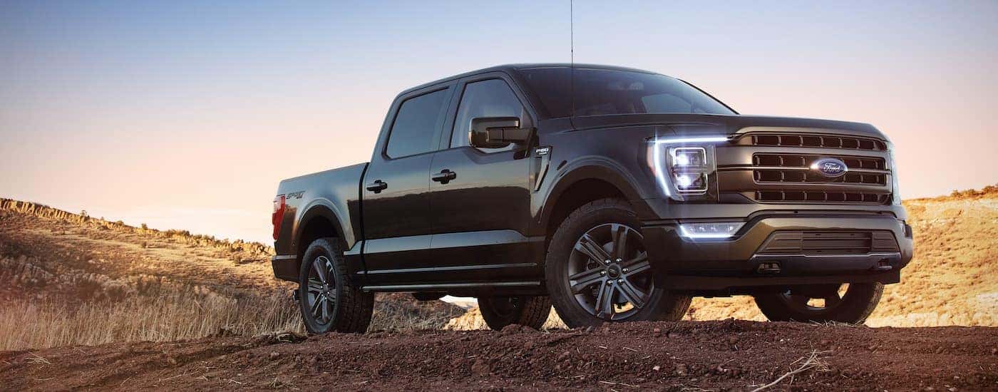 A black 2022 Ford F-150 is shown from the front at an angle after leaving a dealer that has a used Ford F-150 for sale.