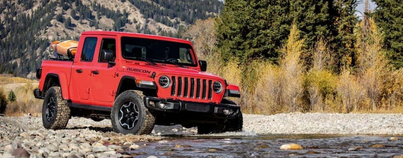 A red 2020 Jeep Gladiator Rubicon is shown driving off-road.