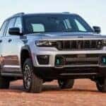 A silver 2023 Jeep Grand Cherokee 4xe for sale is shown parked off-road.