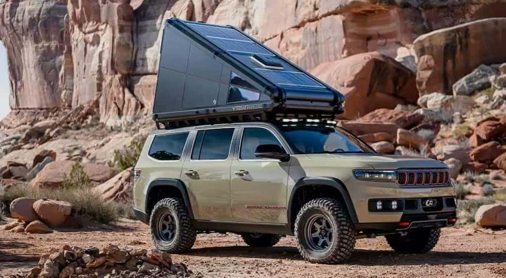 A green 2023 Jeep Grand Wagoneer Overland Concept is shown parked off-road.