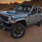 A silver 2024 Jeep Wrangler Rubicon 4xe is shown from the front at an angle.