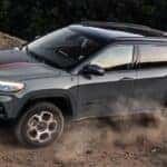 A grey 2023 Jeep Compass is shown driving from a Colorado Jeep dealership.