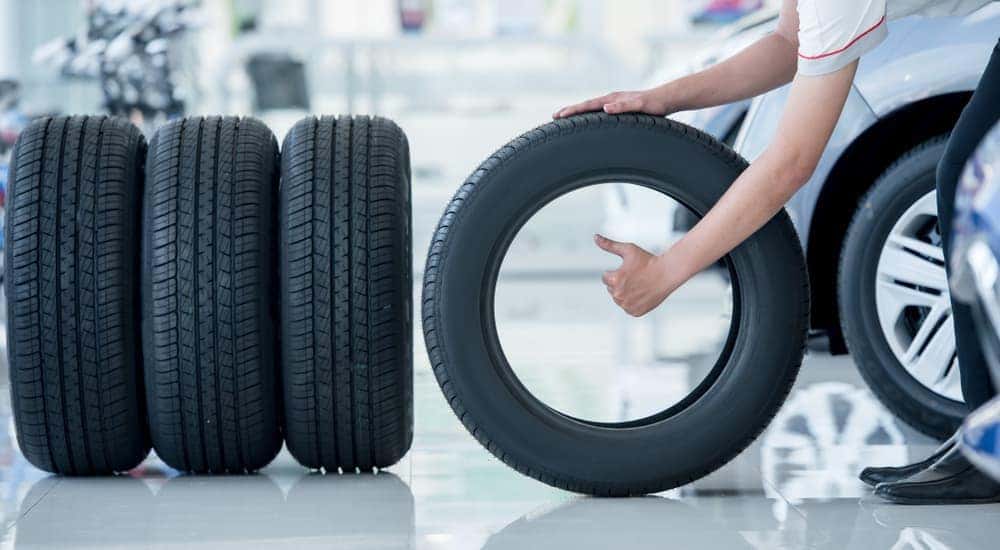 A person is shown lining up a set of tires.