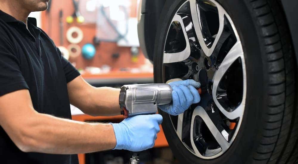 A mechanic is shown working on a vehicle.